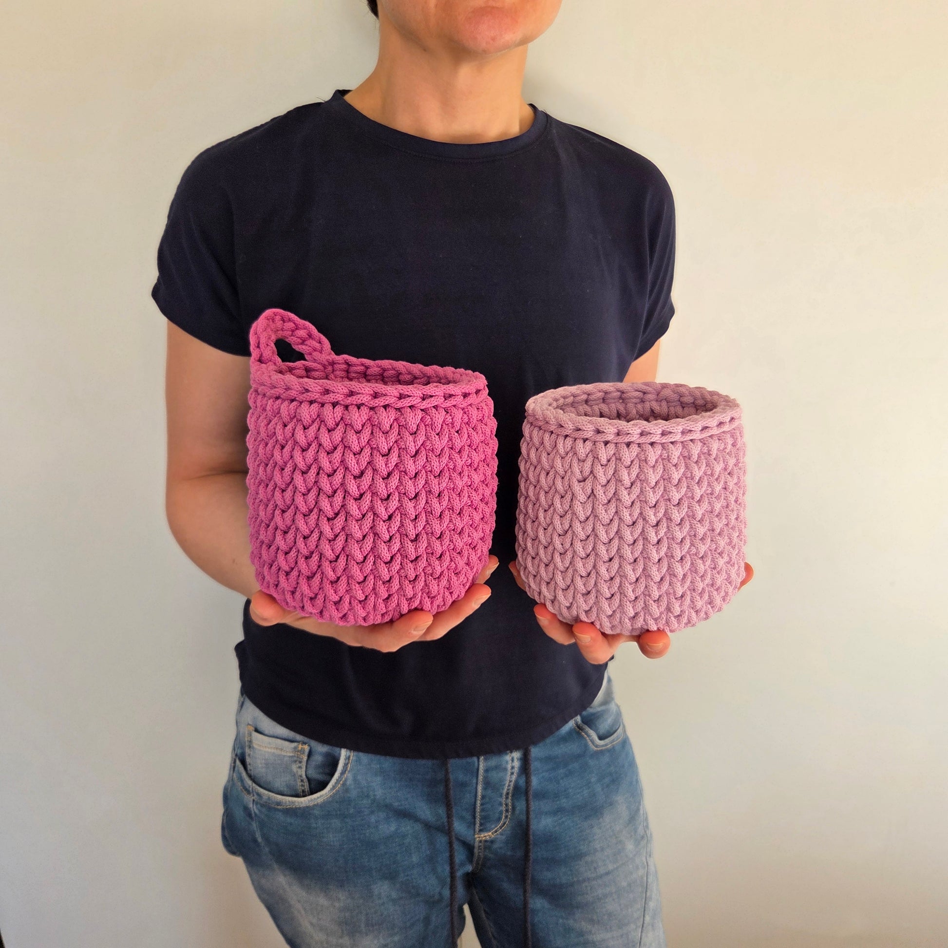 person holding two crochet baskets