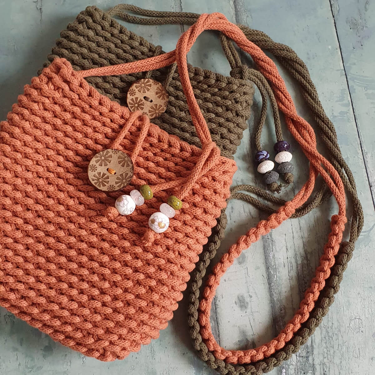 Knitted bag with decorative buttons and beads on a wooden surface