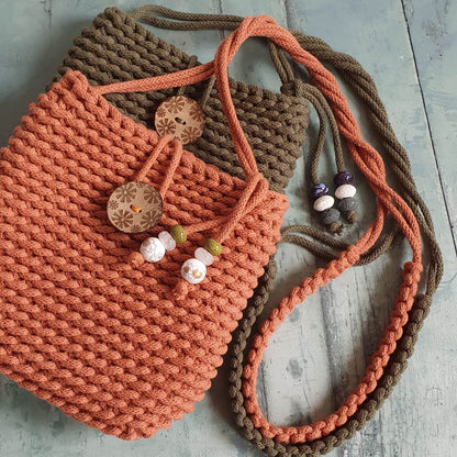 Knitted bag with decorative buttons and beads on a wooden surface