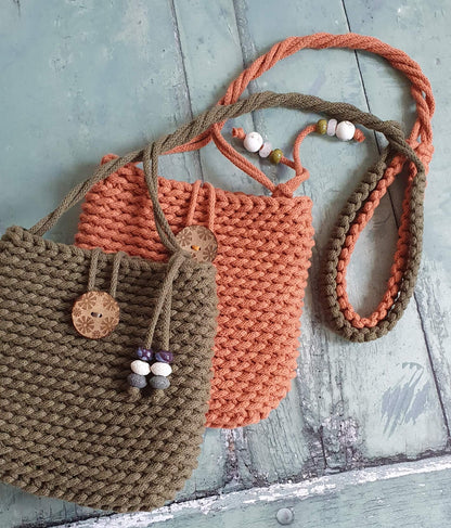 Two knitted bags, one brown and one orange, on a wooden surface.
