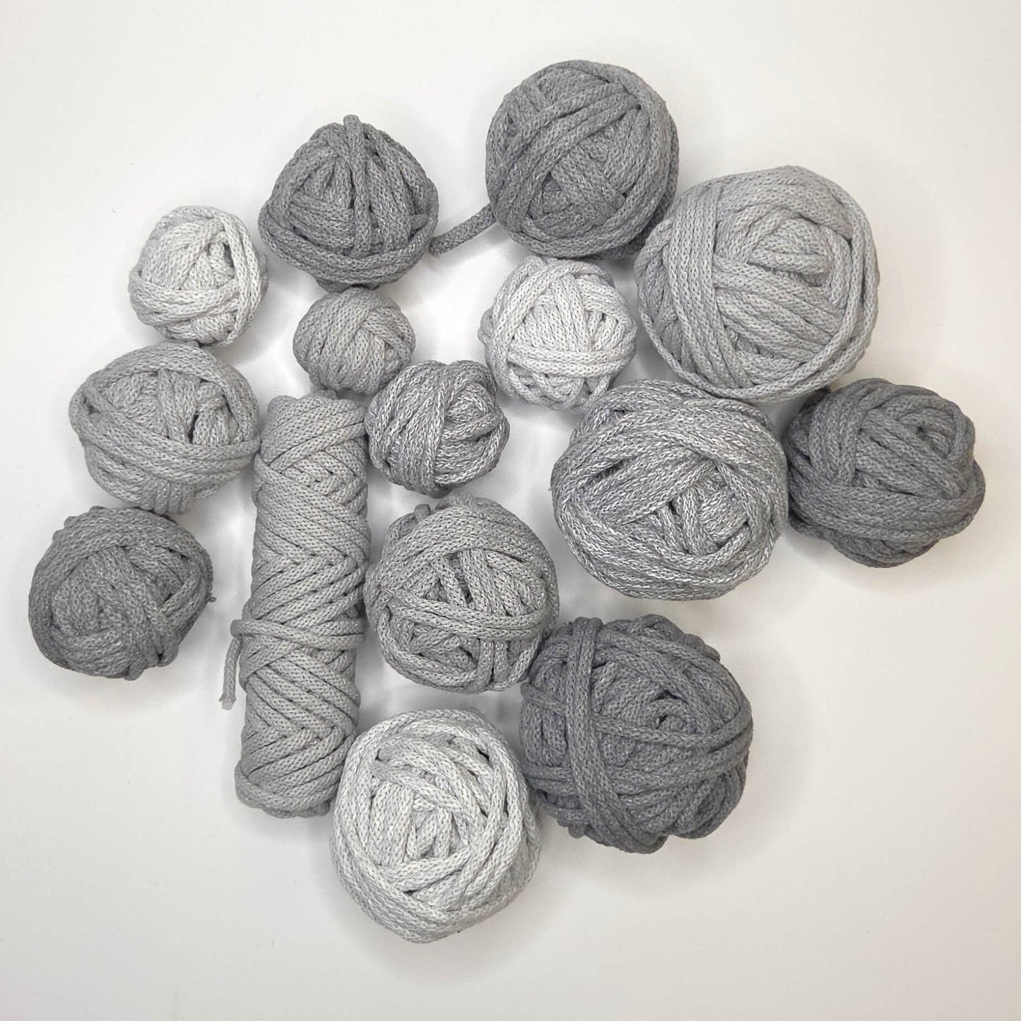 Collection of gray yarn balls on a white background