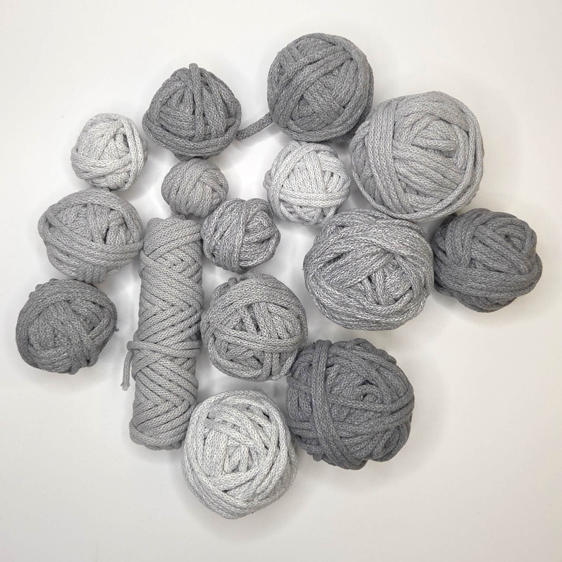 Collection of gray yarn balls on a white background