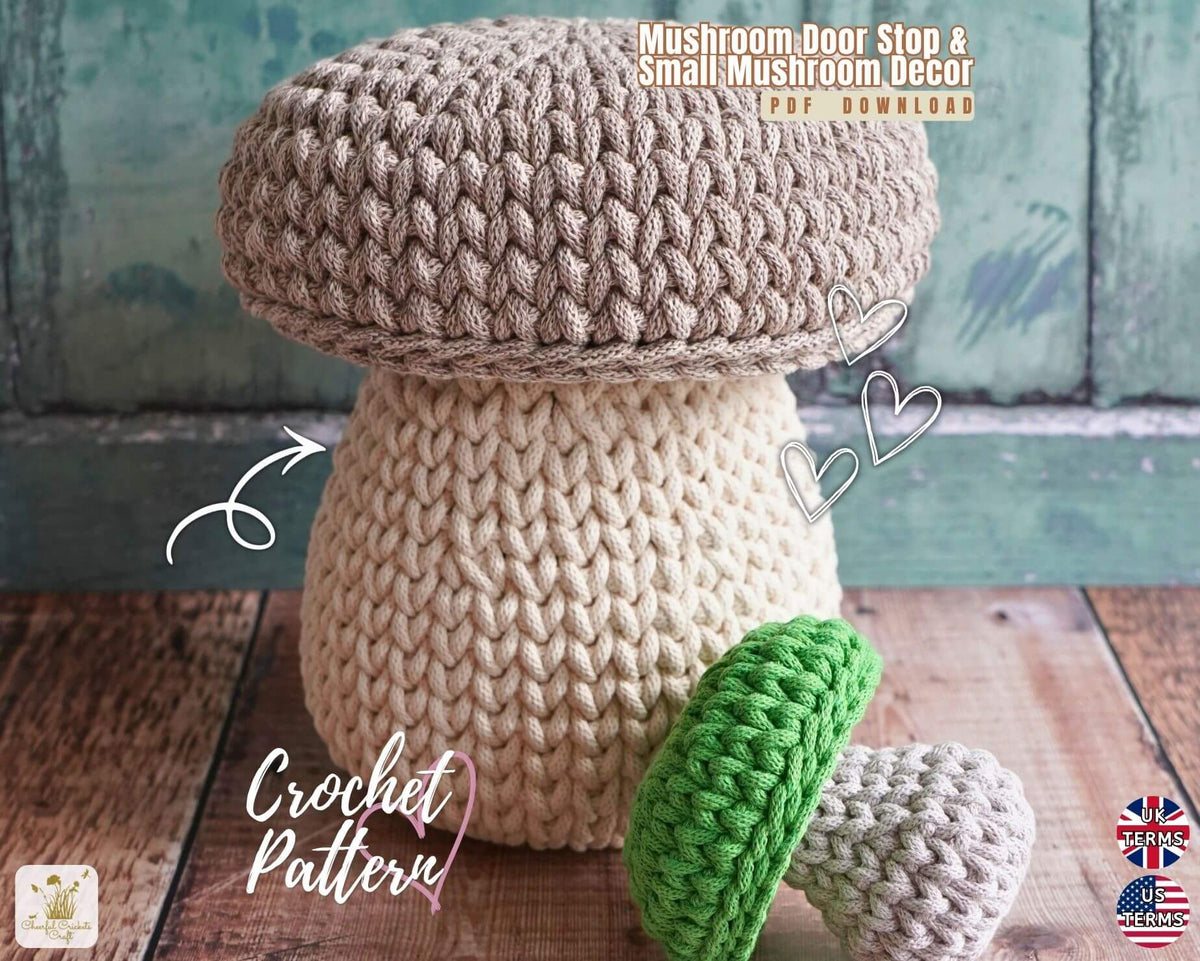 A mushroom-shaped crochet stool or ottoman shown on a rustic wooden surface against a distressed teal wall. The main product is a large crocheted mushroom with a taupe cap and cream stem.
