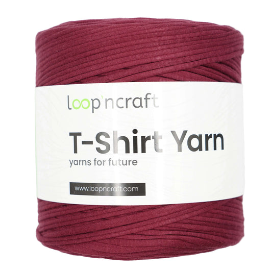 A spool of LoopnCraft T-Shirt Yarn in a deep burgundy color, wrapped with a white paper label that reads 'loopncraft T-Shirt Yarn'.
