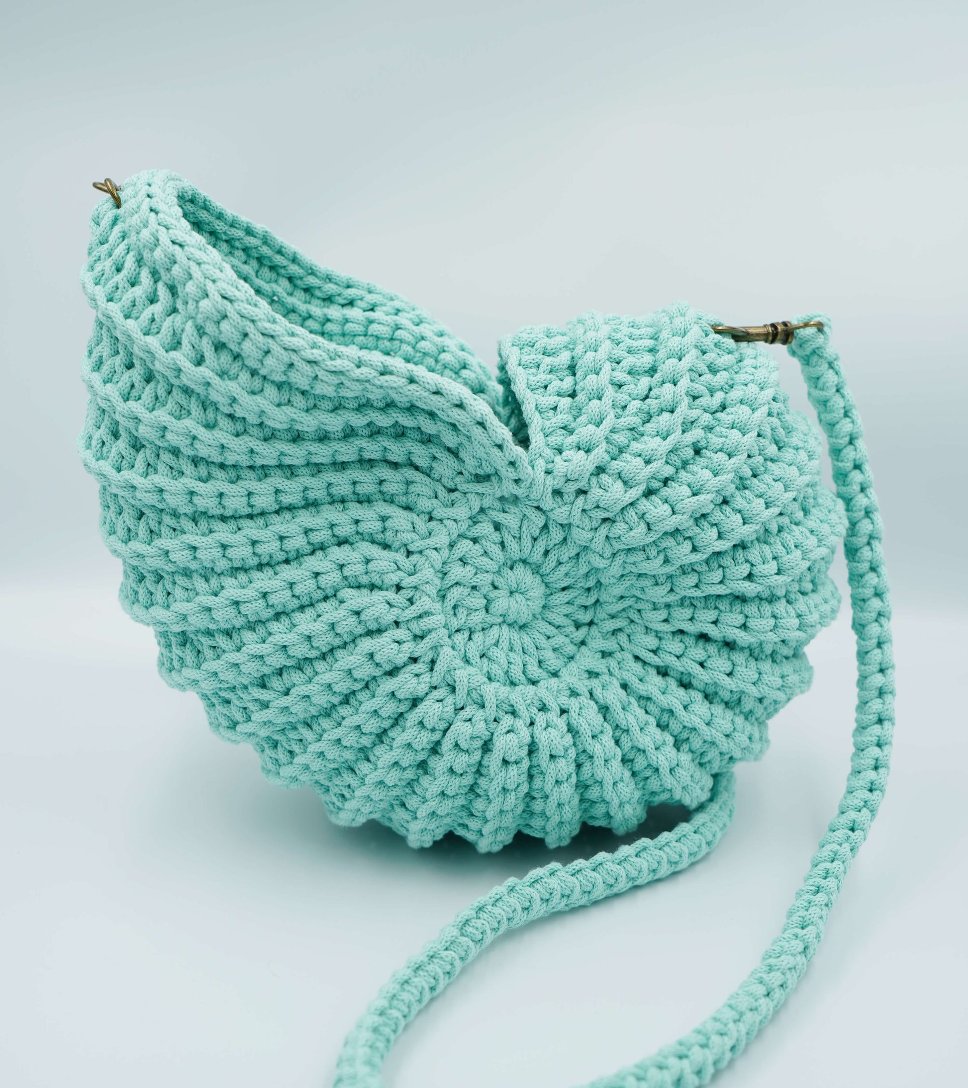 Turquoise knitted bag on a light gray background