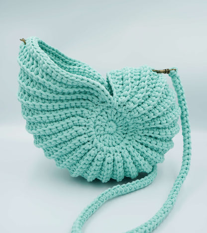 Turquoise knitted bag on a light gray background