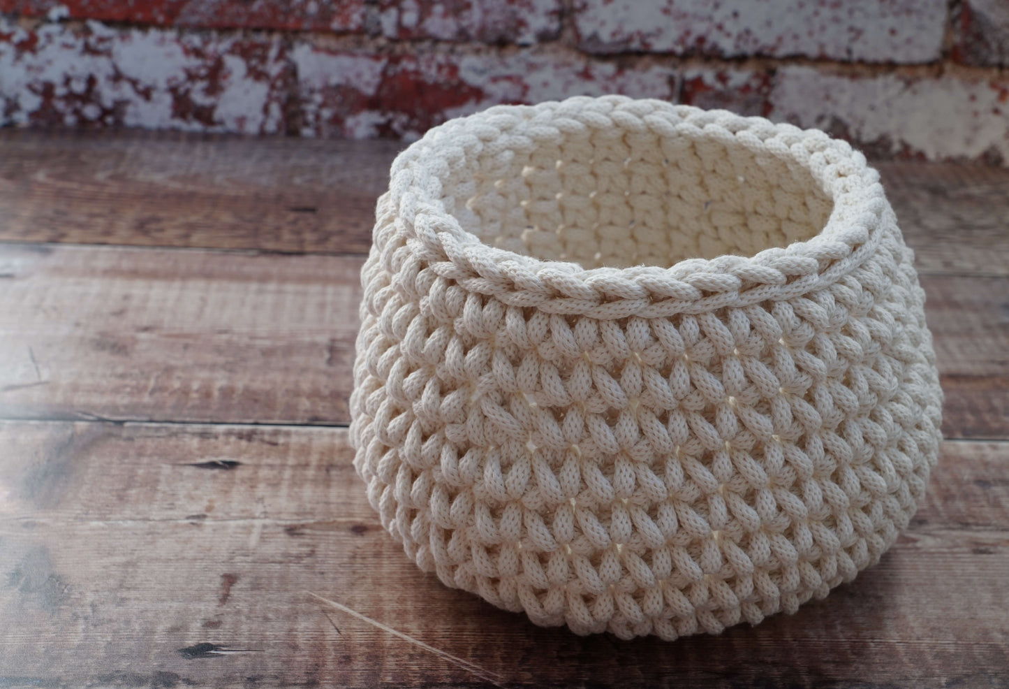 Beige woven basket on a wooden surface with a rustic background