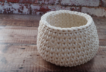 Beige woven basket on a wooden surface with a rustic background