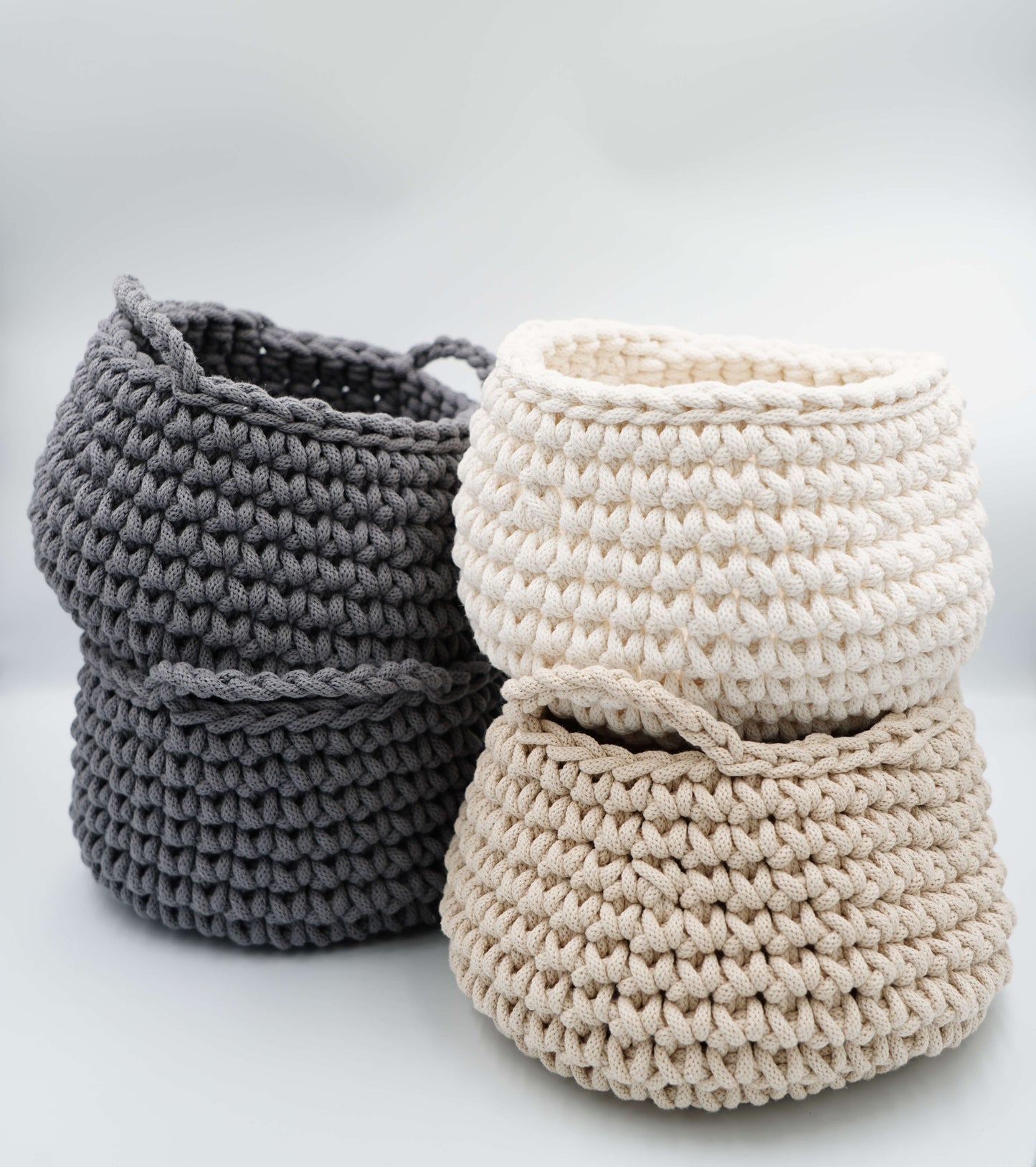 Two crocheted baskets, one gray and one beige, on a light background