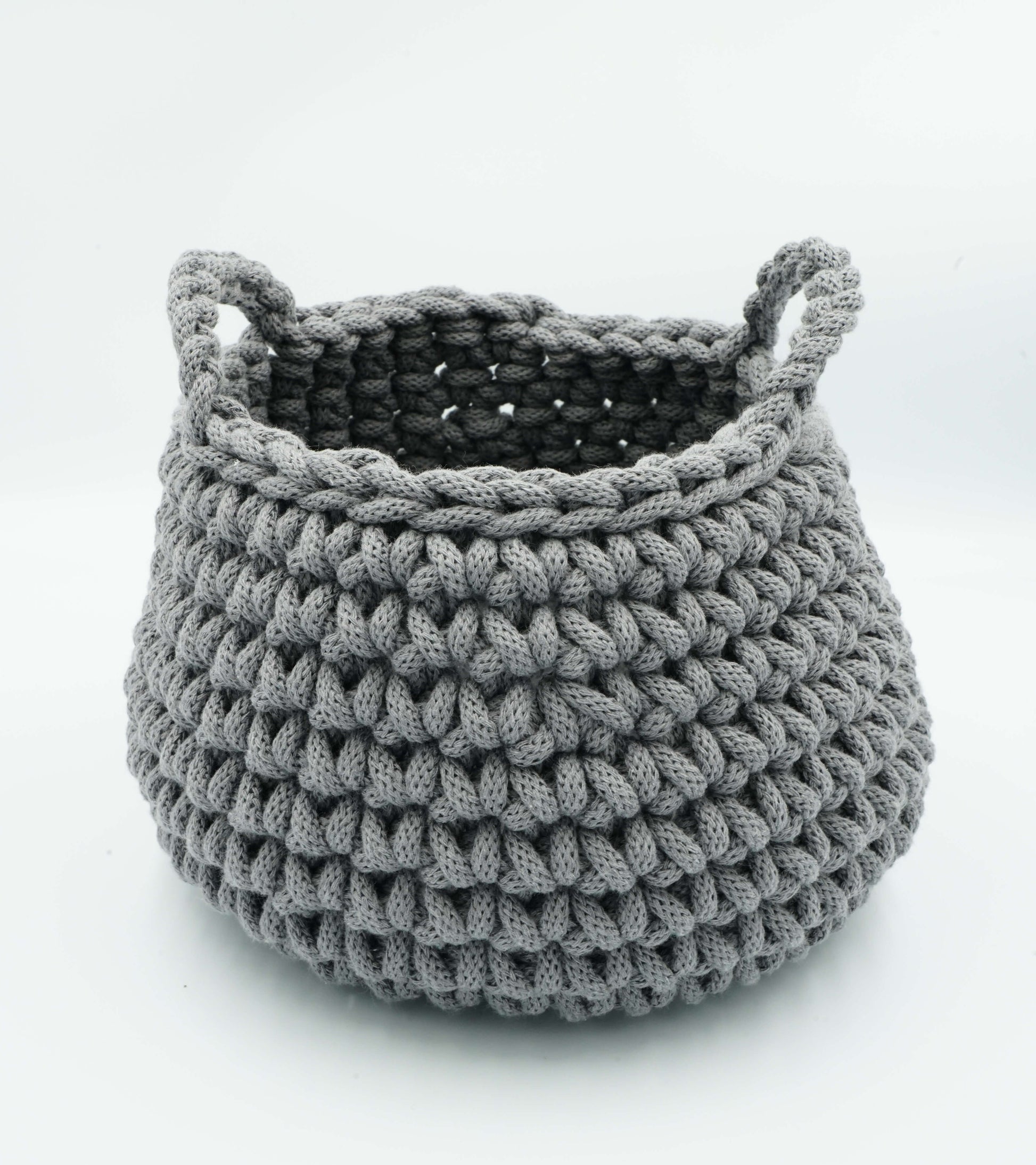 Gray crocheted basket with handles on a white background