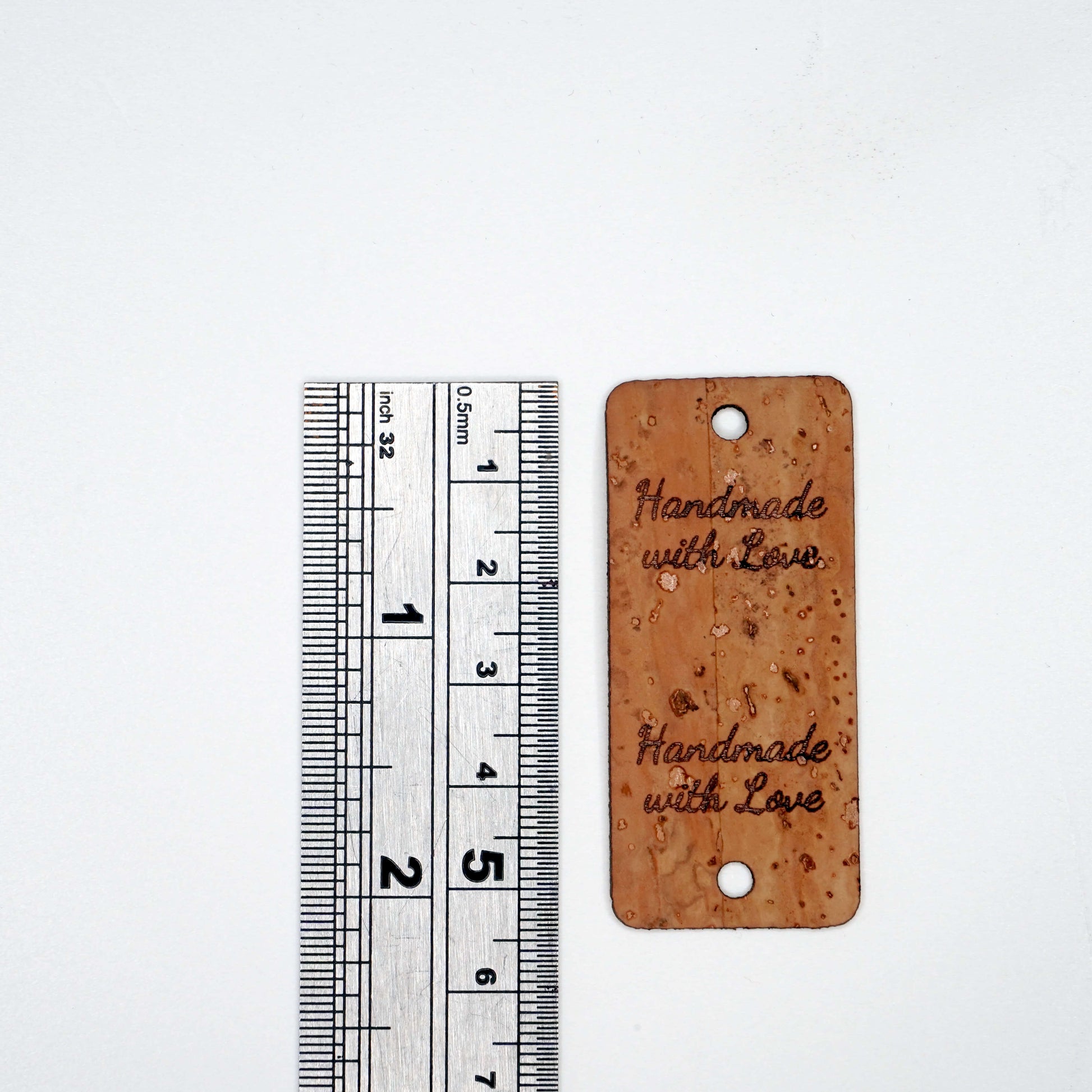 Cork tag with 'Handmade with Love' text next to a ruler on a white background