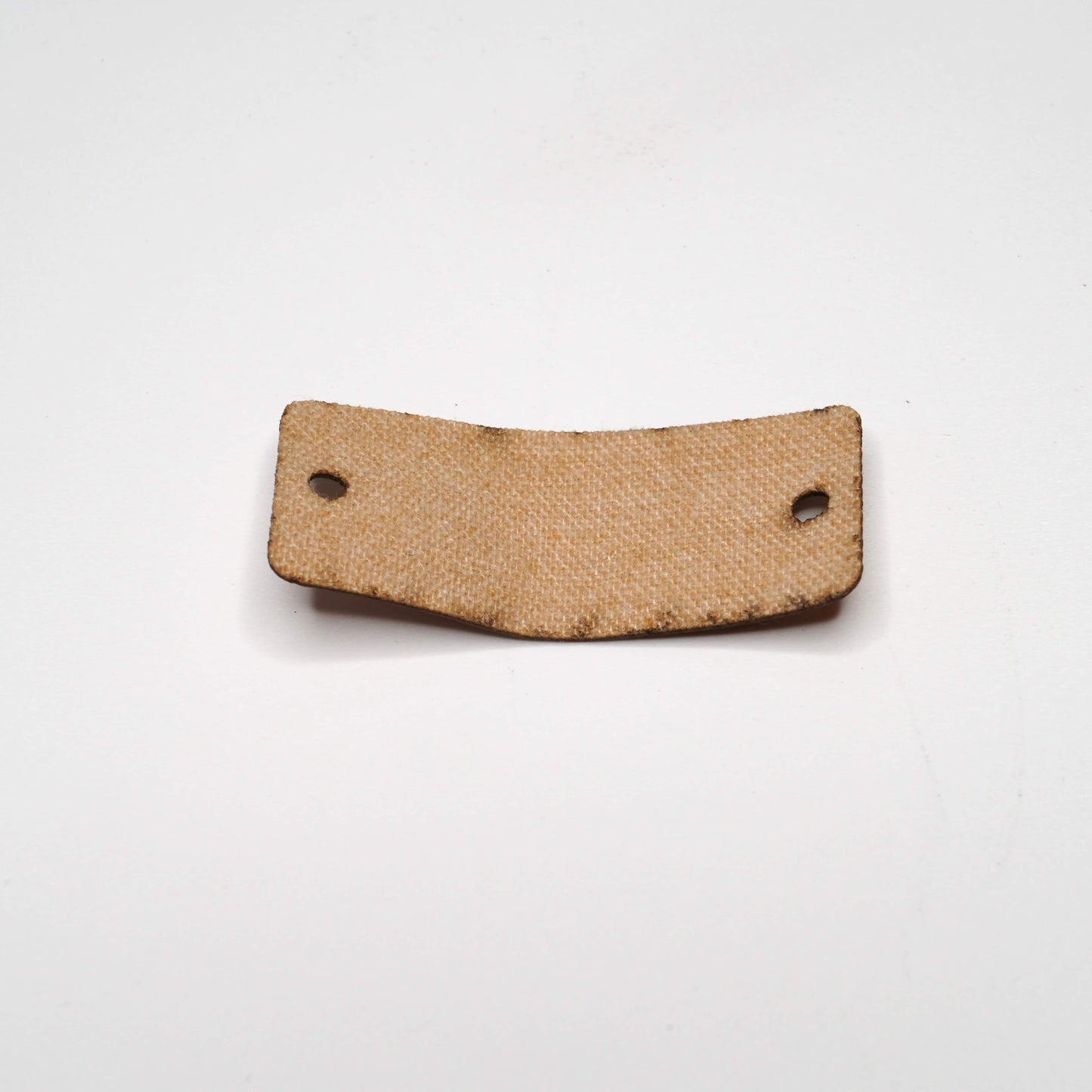 Brown leather patch with two holes on a white background