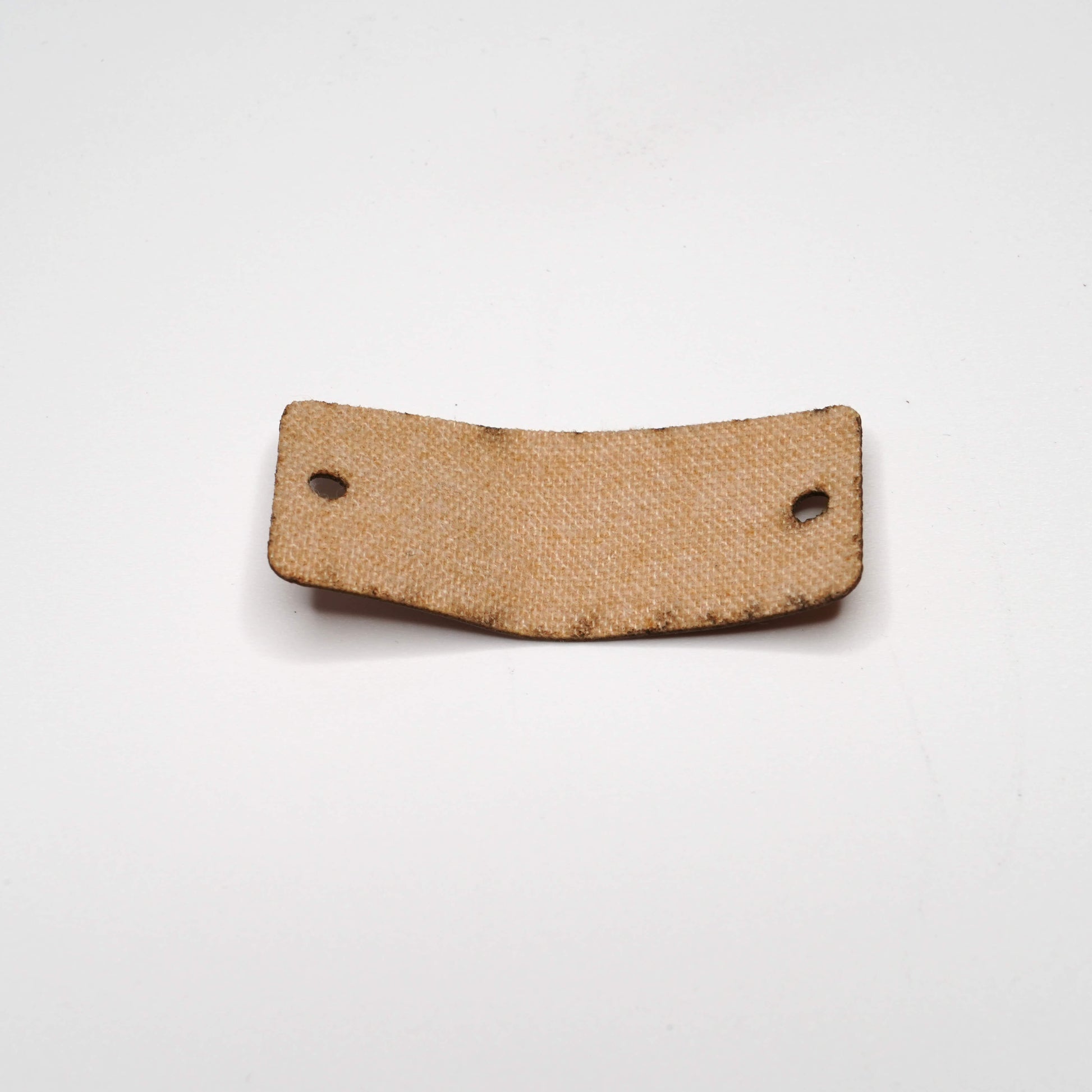 Brown leather patch with two holes on a white background