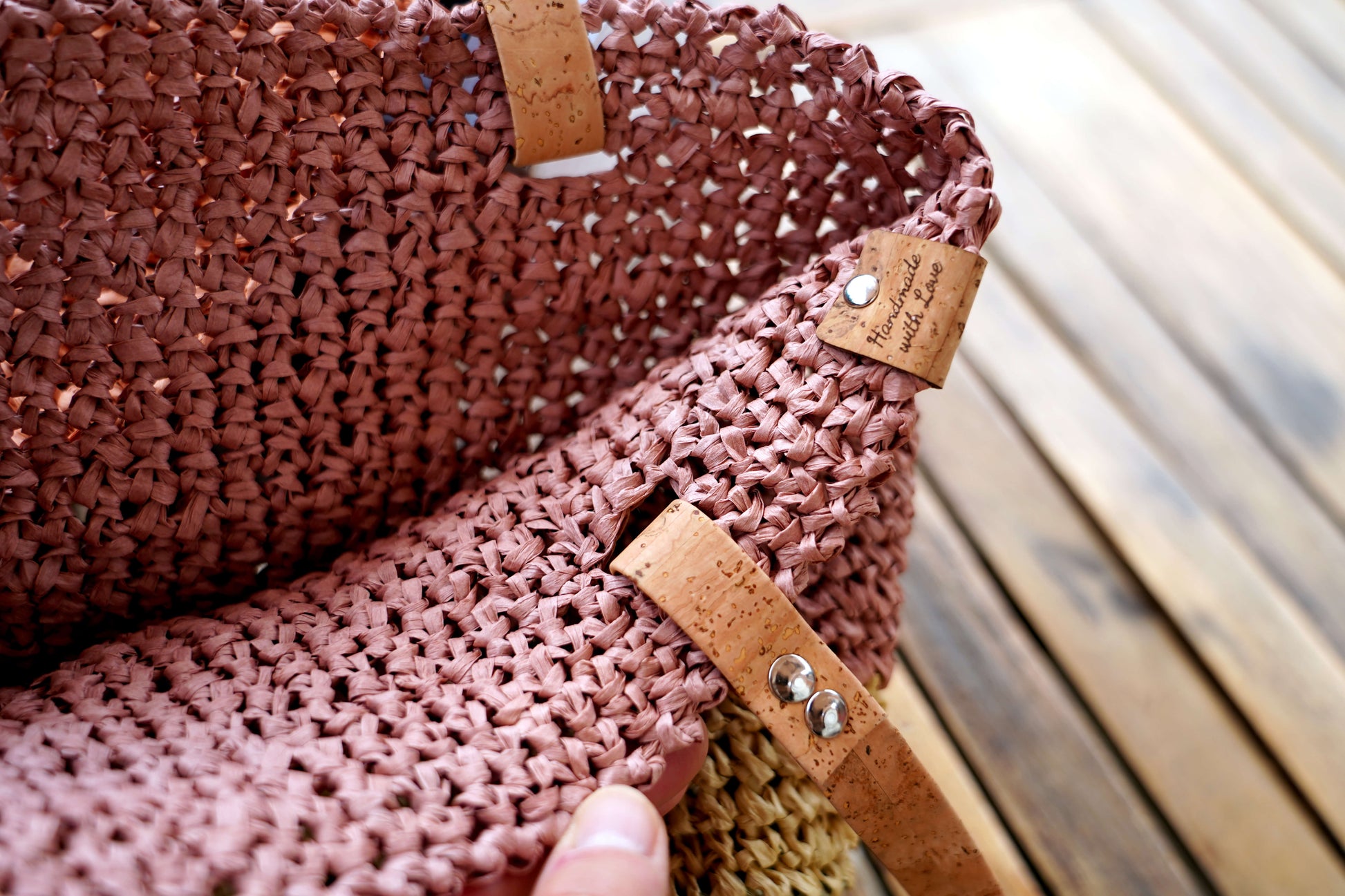 Close-up of a woven bag with leather straps and a blurred background