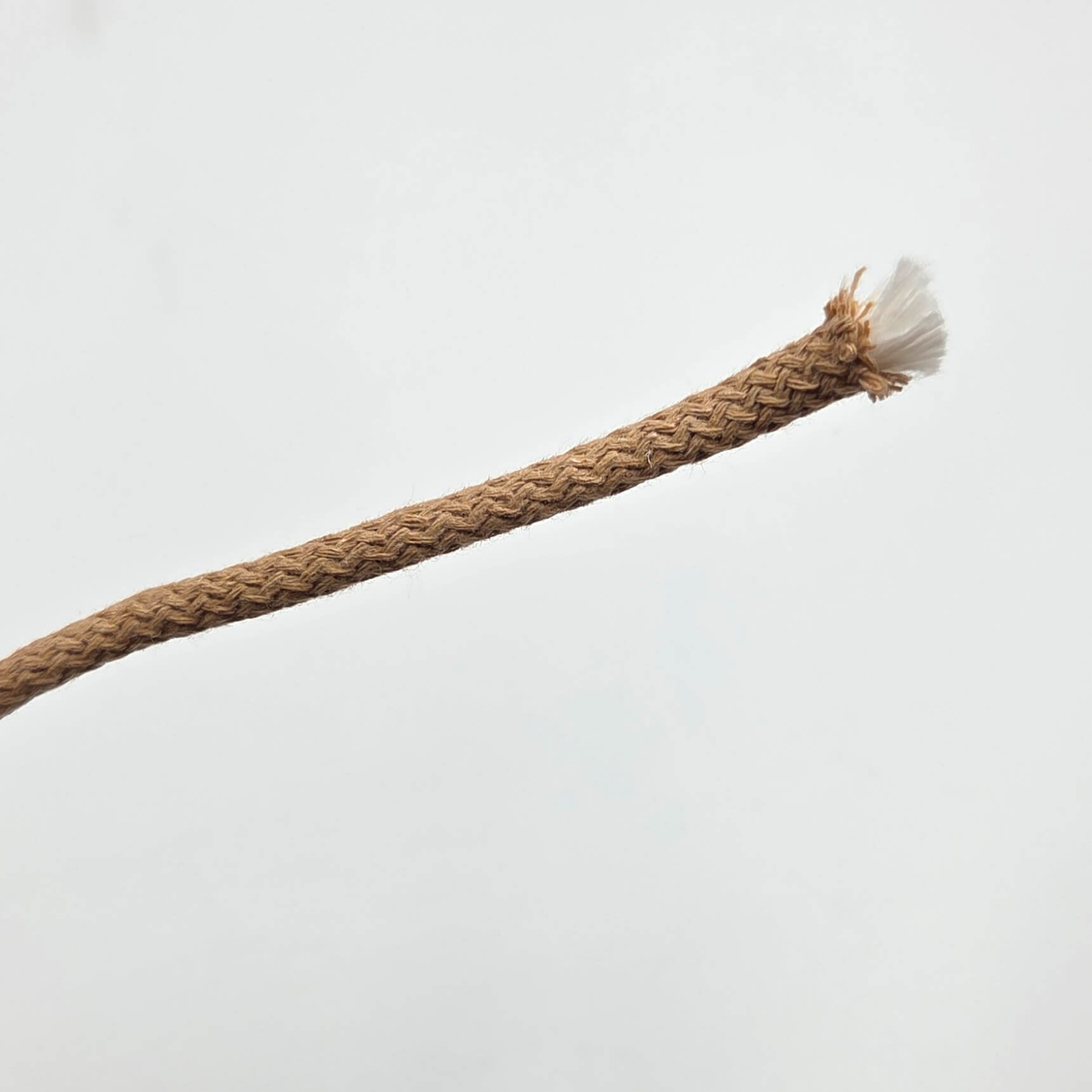 A close-up of a braided tan rope or cord with a frayed white end, photographed against a plain light gray background.
