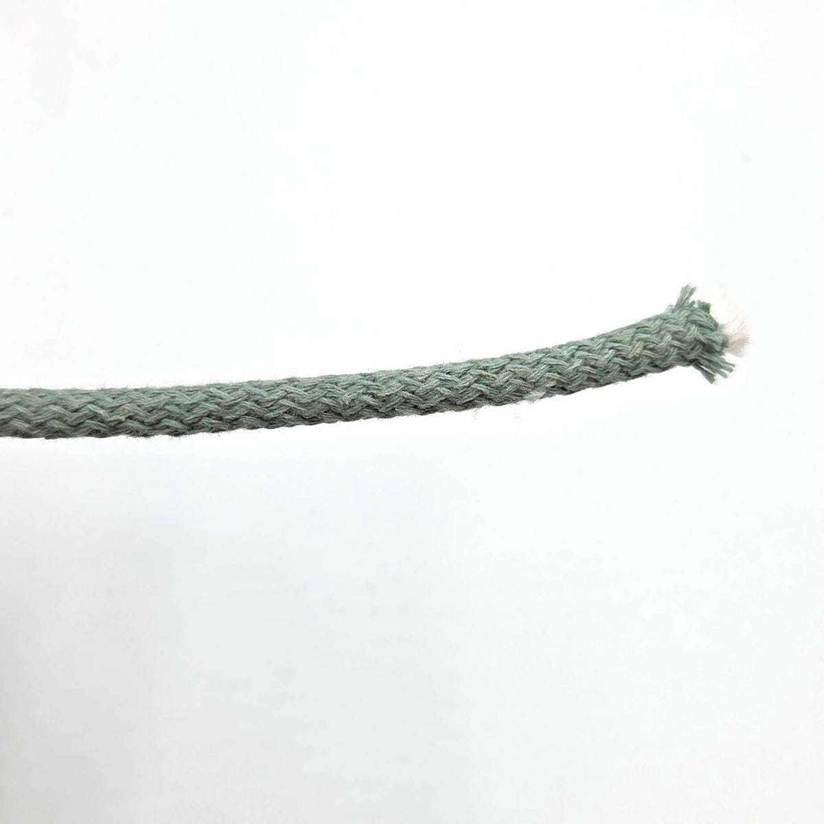 A close-up of a braided green cord or rope extending from the left side, ending in a frayed tip on the right, against a plain white background.