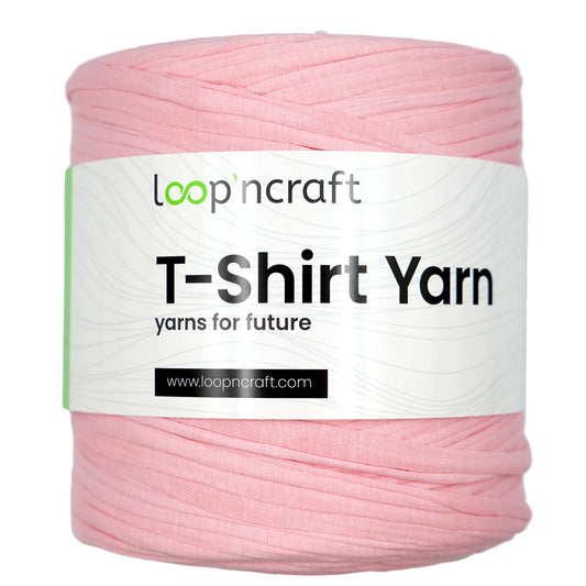 A spool of light pink T-shirt yarn wrapped with a white paper label that reads 'loop'ncraft T-Shirt Yarn' on a light gray background.