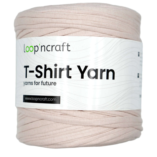 A spool of Loop 'ncraft T-Shirt Yarn in a light beige color, featuring a white paper label with black text.