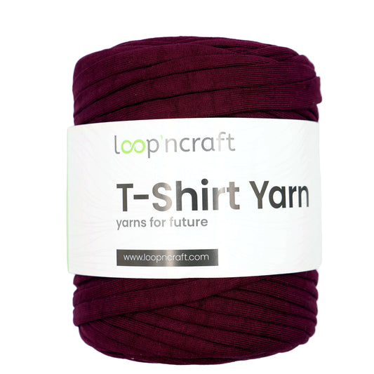 A skein of Loop'n Craft T-Shirt Yarn in a deep burgundy/plum color, wrapped with a white paper label that reads 'T-Shirt Yarn' and shows the brand 'loop'n craft'.