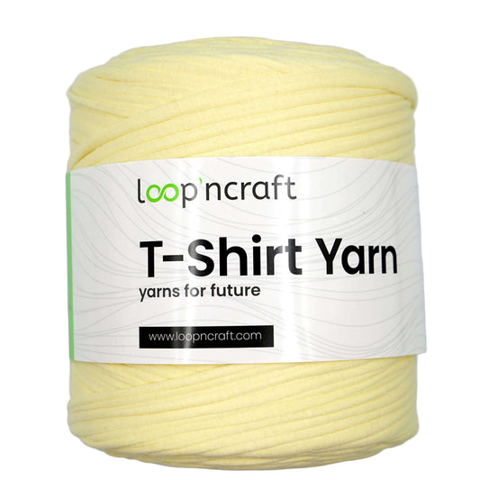 A skein of pale yellow T-shirt yarn with a white paper label that reads 'loop'n craft T-Shirt Yarn' on a plain white background.