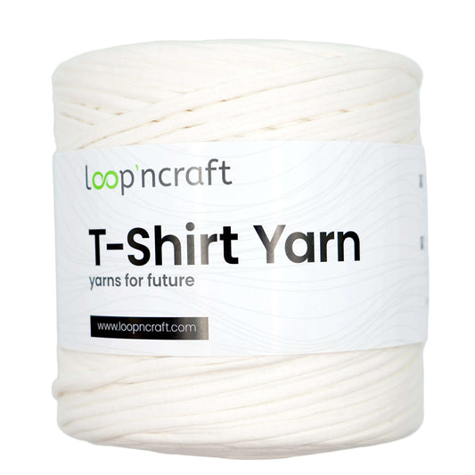 A spool of off-white T-shirt yarn with a white paper label that reads 'loop'n craft T-Shirt Yarn' on a light gray background.